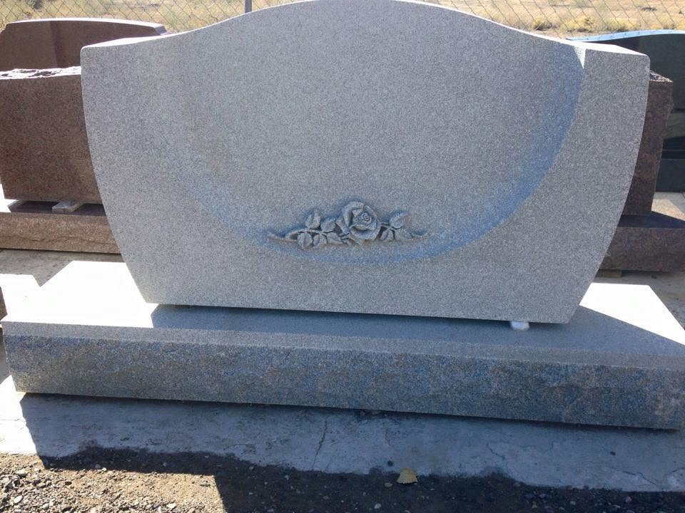 Granite monument with recessed raised rose sculpture carving