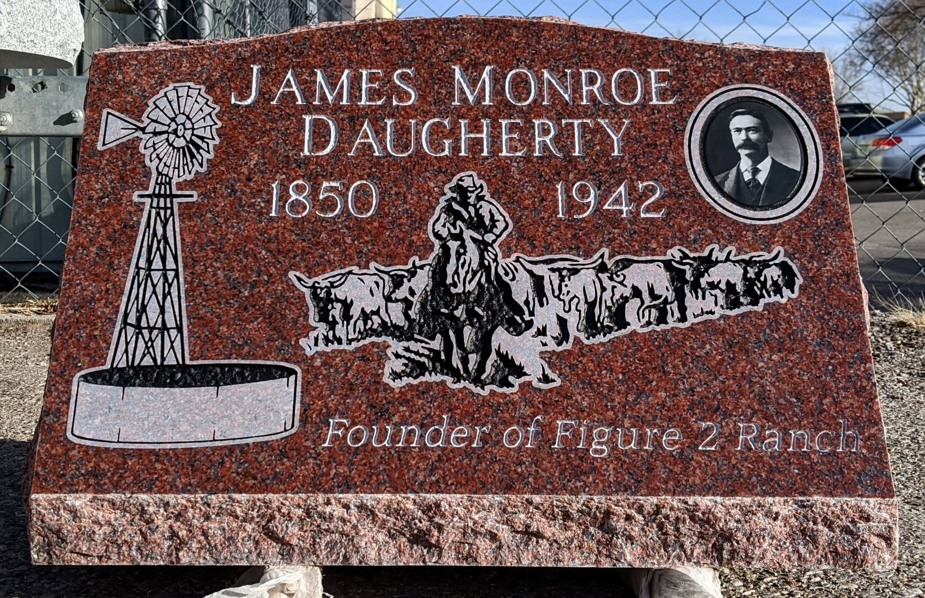 James Monroe Daugherty red granite slant with windmill, cowboy cattle drive engraving, portrait photo tile, and "Founder of Figure 2 Ranch" inscription