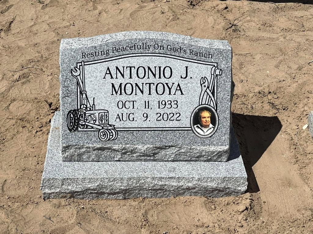 Antonio J. Montoya gray granite slant with engraved tractor, mechanic tools, porcelain photo tile, and 'Resting Peacefully On God's Ranch' inscription