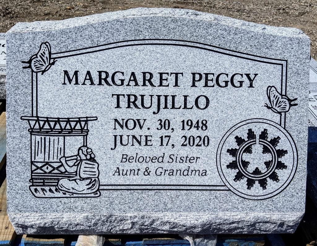 Margaret Peggy Trujillo gray granite slant with engraved butterflies Native American drum weaver snowflake wheel and Beloved Sister Aunt and Grandma inscription Nov 30 1948 to June 17 2020