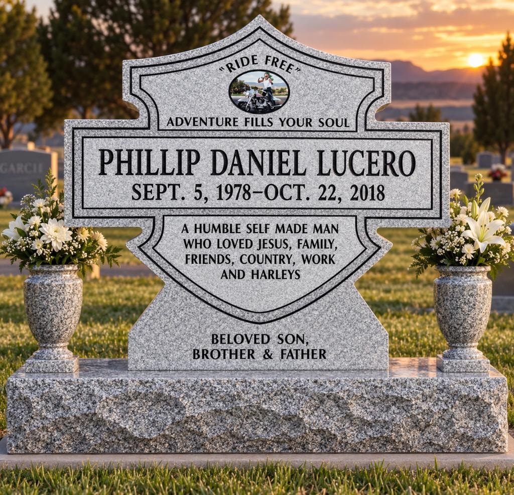 Phillip Daniel Lucero 1978–2018 gray granite Harley-Davidson shield-shaped upright monument with motorcycle portrait photo tile, companion vases with white lilies, and inscription Ride Free Adventure Fills Your Soul
