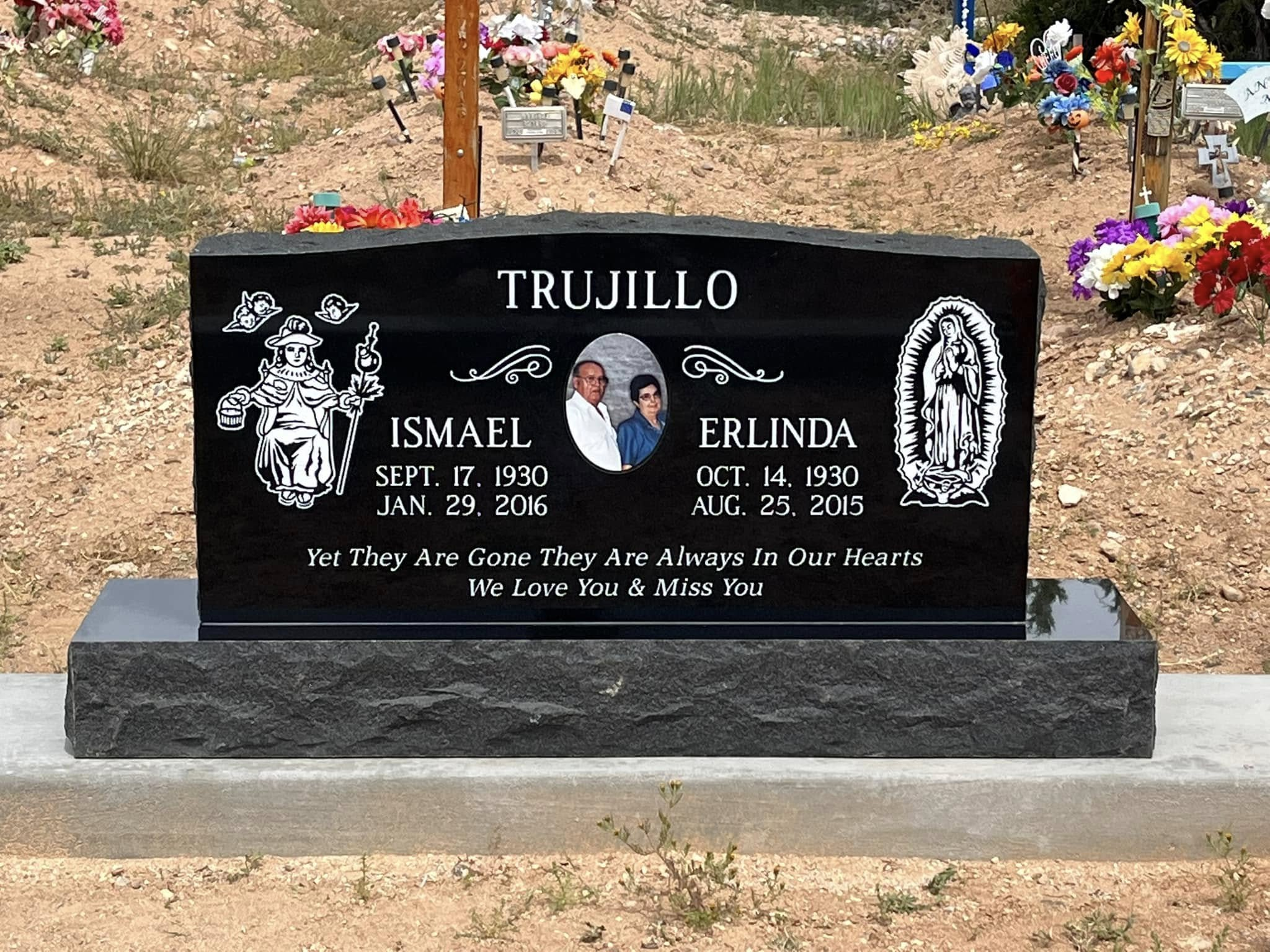Trujillo family black granite double upright with San Isidro and Our Lady of Guadalupe engravings and couple portrait
